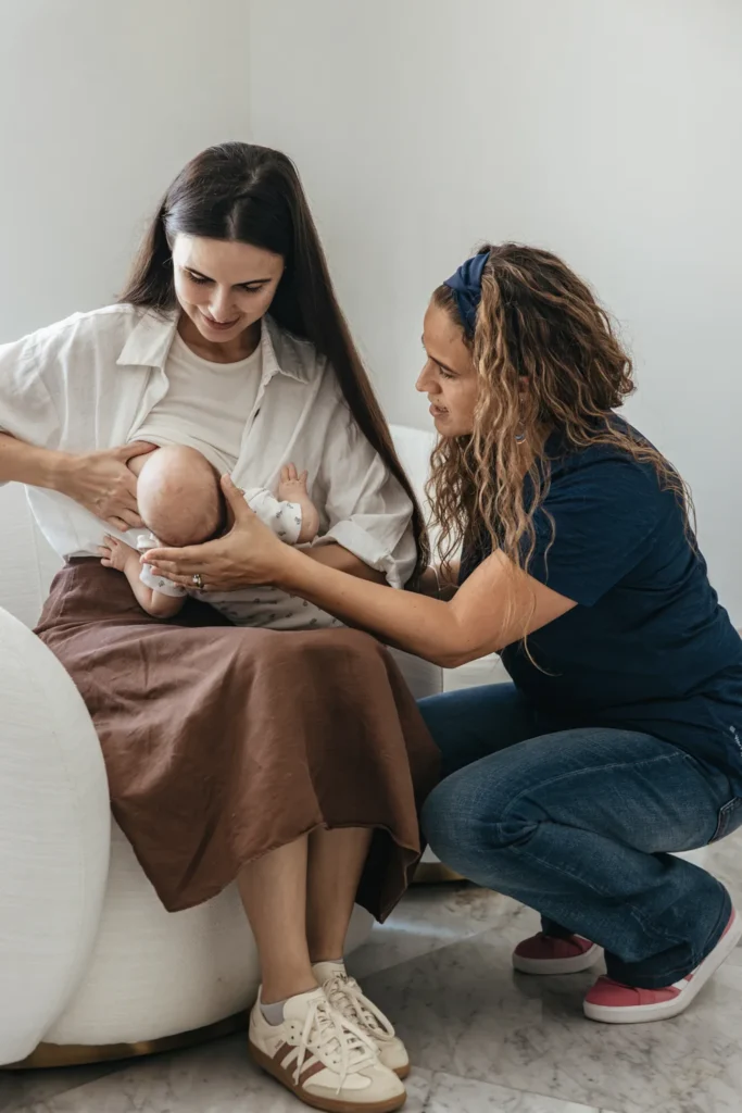 Silvia supports a seated mother breastfeeding her baby.